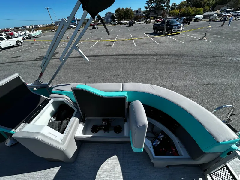 Slide: The Image of 2025 Berkshire 23RFX STS 3.0 boat interior with teal and gray seating in a parking lot. - 20