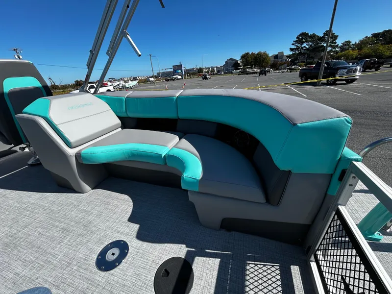 Slide: The Image of 2025 Berkshire 23RFX STS 3.0 boat with teal and gray seating in a parking lot. - 22