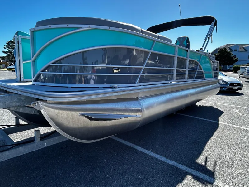Slide: The Image of 2025 Berkshire 23RFX STS 3.0 pontoon boat in parking lot, teal and silver design. - 5
