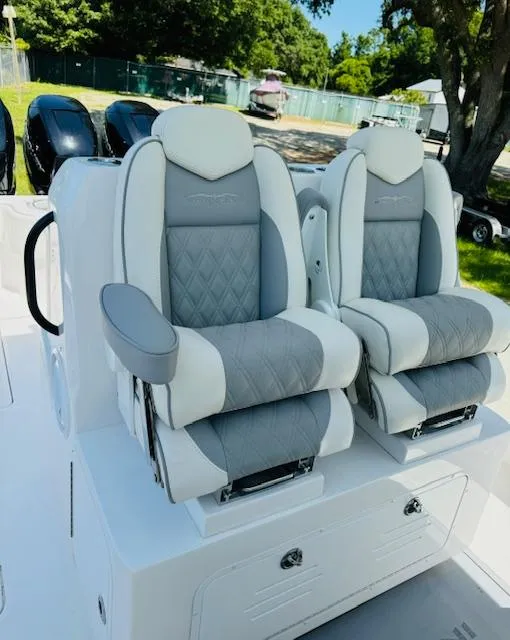 Slide: The Image of 2022 Invincible 36 Open Fisherman boat seats, gray and white upholstery, outdoor setting. - 13