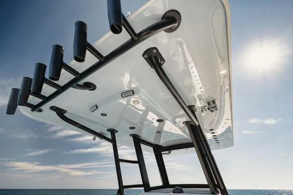 Slide: The Image of Invincible 36 Open Fisherman 2022 boat, view of T-top and rod holders against blue sky. - 7