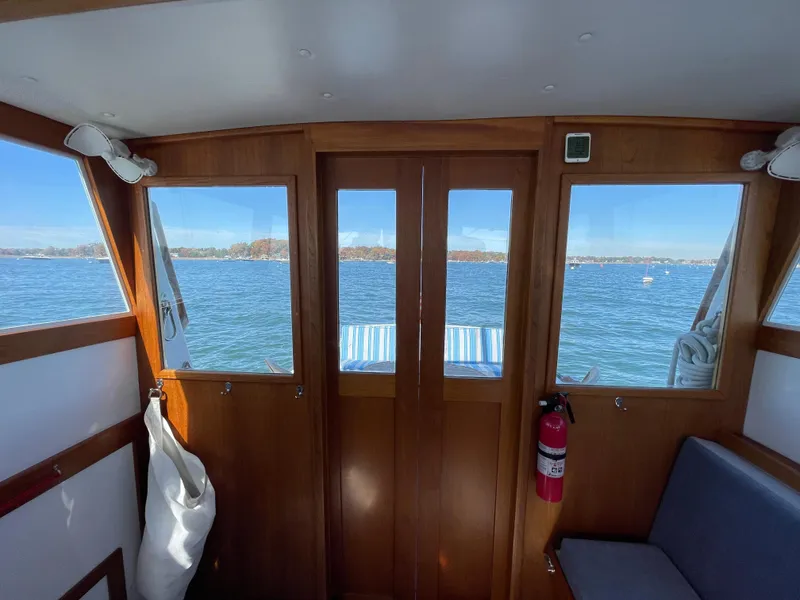 Slide: The Image of Interior view of 1988 Ellis 28 boat with wooden doors and scenic water view. - 12