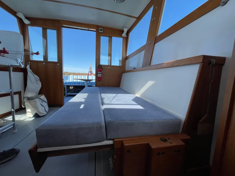 Slide: The Image of Interior of a 1988 Ellis 28 boat with cushioned seating and wooden accents. - 14