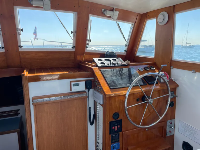 Slide: The Image of 1988 Ellis 28 boat interior with wooden helm, steering wheel, and ocean view. - 15