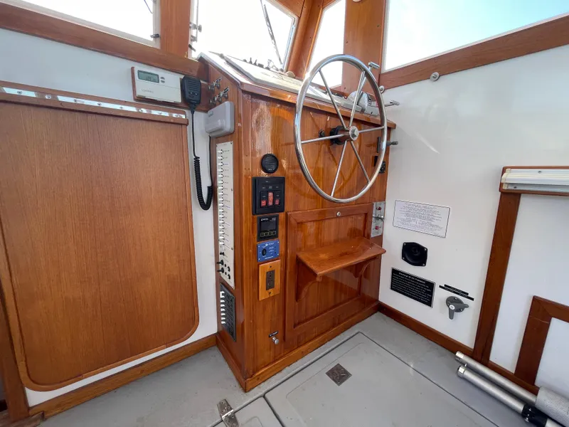Slide: The Image of 1988 Ellis 28 boat helm with wooden paneling and steering wheel. - 17