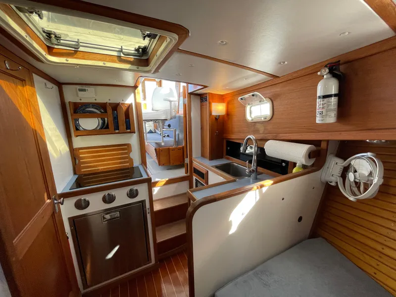 Slide: The Image of Interior of 1988 Ellis 28 boat with kitchen, seating, and wooden finishes. - 24