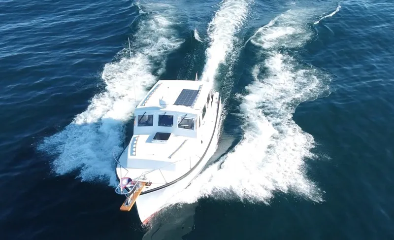 Slide: The Image of 1988 Ellis 28 boat cruising on open water, creating a wake behind. - 3