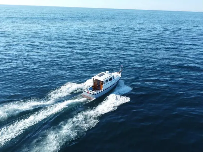 Slide: The Image of Aerial view of 1988 Ellis 28 boat cruising on open sea. - 4