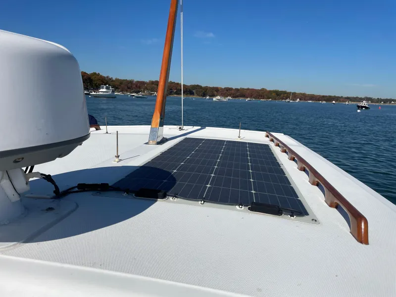 Slide: The Image of 1988 Ellis 28 boat with solar panels on deck, cruising on a sunny day. - 9