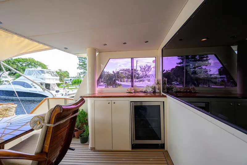 Slide: The Image of 1991 Hatteras 78 CMY yacht deck with seating, cabinetry, and scenic marina view. - 16