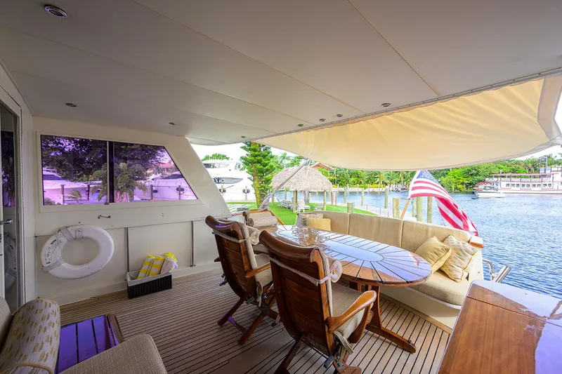 Slide: The Image of Luxurious 1991 Hatteras 78 CMY yacht deck with seating, table, and scenic waterfront view. - 17