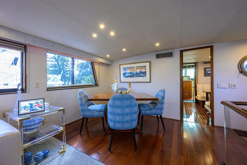 Slide: The Image of Luxurious interior of 1991 Hatteras 78 CMY yacht with elegant dining area and blue chairs. - 25