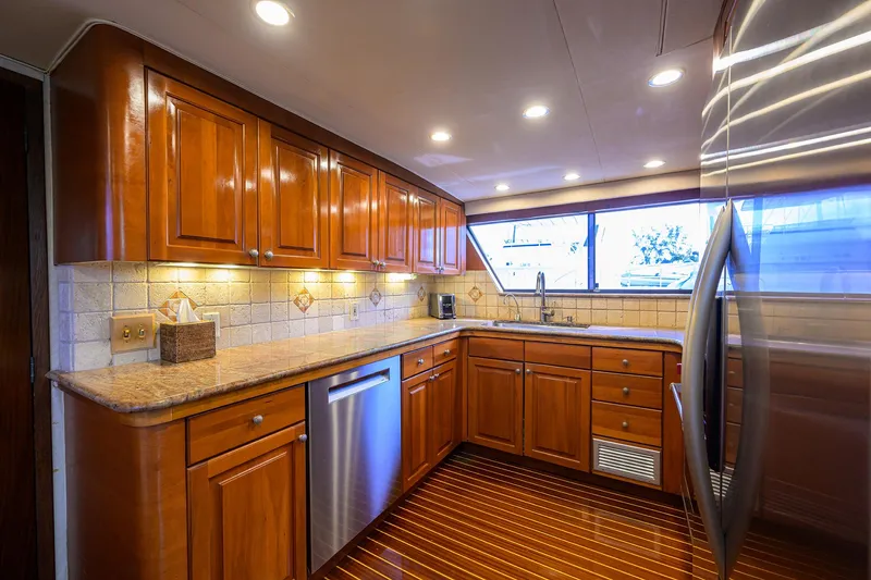 Slide: The Image of Luxurious kitchen interior of 1991 Hatteras 78 CMY yacht with wooden cabinets and modern appliances. - 28