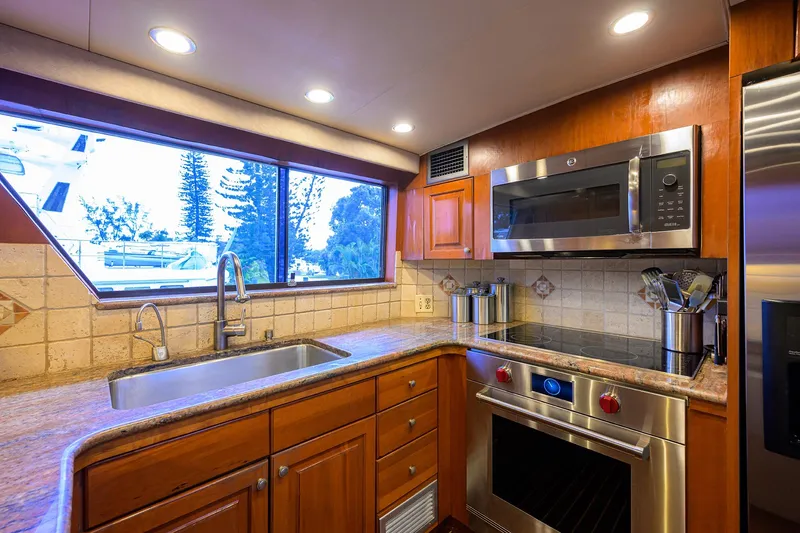 Slide: The Image of Luxurious kitchen interior of 1991 Hatteras 78 CMY yacht with modern appliances and wood cabinetry. - 29