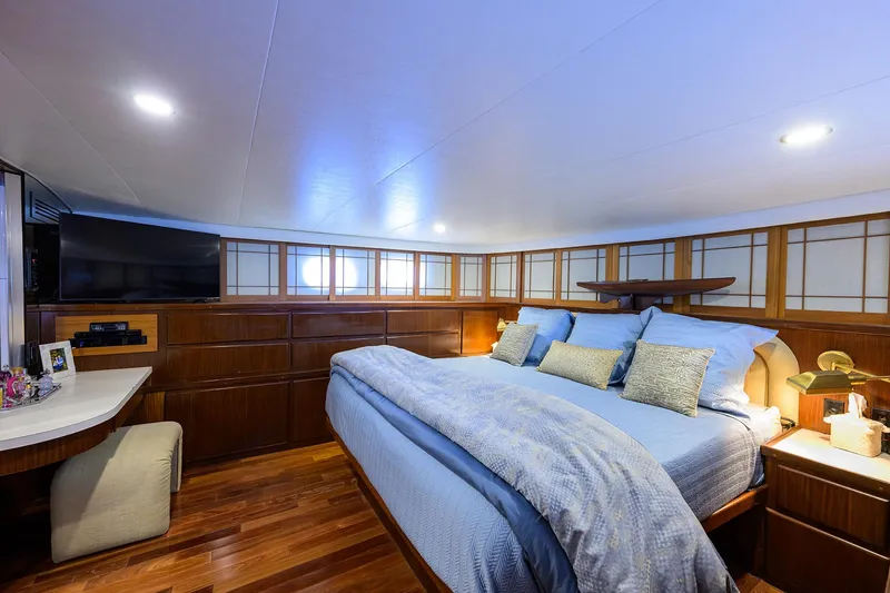 Slide: The Image of Luxurious bedroom interior of 1991 Hatteras 78 CMY yacht with wood paneling and cozy bedding. - 32
