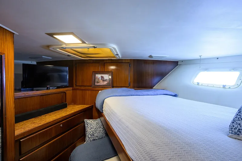 Slide: The Image of Luxurious cabin interior of 1991 Hatteras 78 CMY yacht with cozy bed and TV. - 41