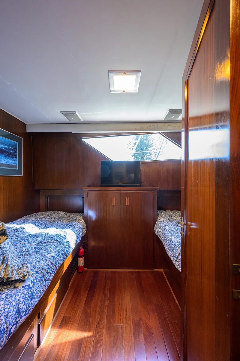 Slide: The Image of Interior of 1991 Hatteras 78 CMY yacht with twin beds and wooden paneling. - 42