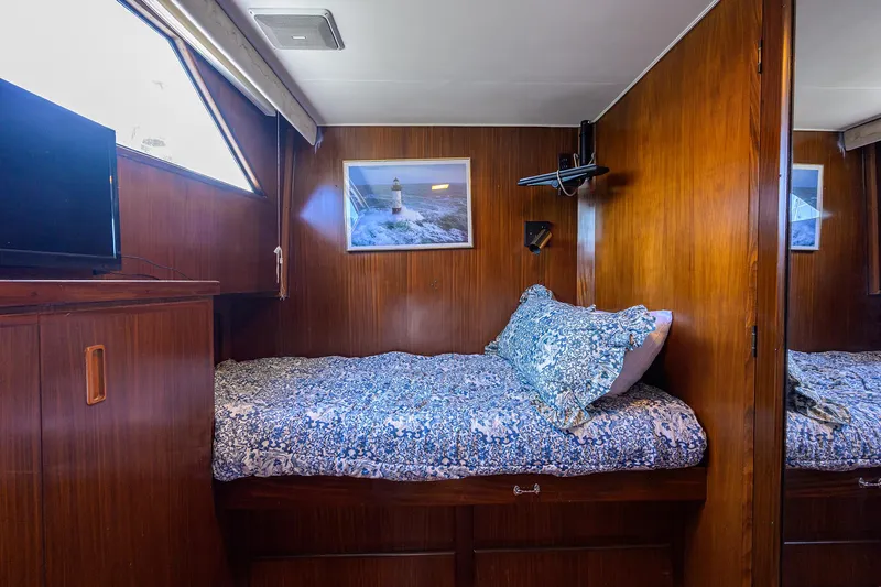 Slide: The Image of Cozy cabin interior of 1991 Hatteras 78 CMY yacht with wooden paneling and single bed. - 44