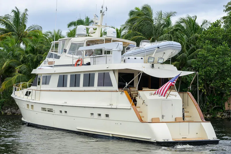 Slide: The Image of 1991 Hatteras 78 CMY yacht cruising near lush palm trees. - 9