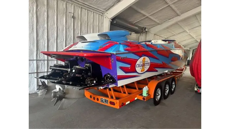 Slide: The Image of 2003 Cigarette 38 Top Gun speedboat with vibrant graphics in a storage facility. - 5