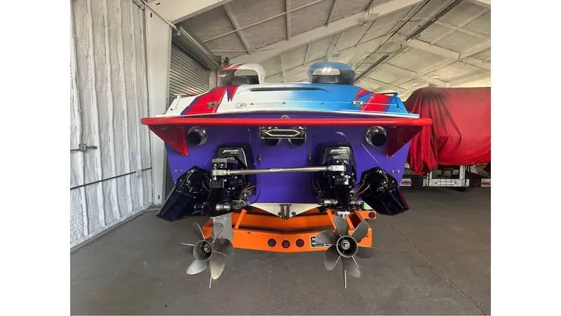 Slide: The Image of 2003 Cigarette 38 Top Gun boat in a garage, rear view with dual propellers. - 7