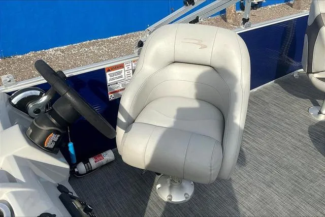 Slide: The Image of Captain's chair on 2021 Bennington 22 SL pontoon boat, featuring a steering wheel and safety equipment. - 21