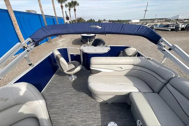 Slide: The Image of 2021 Bennington 22 SL pontoon boat with blue canopy and gray seating. - 24