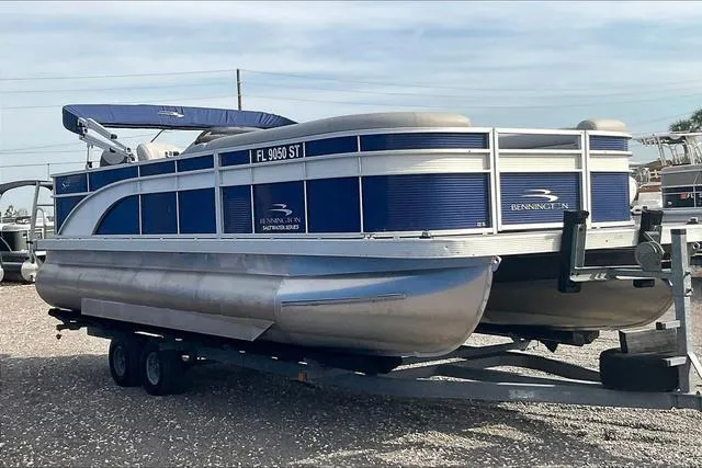 Slide: The Image of 2021 Bennington 22 SL pontoon boat on trailer, blue and silver design. - 3
