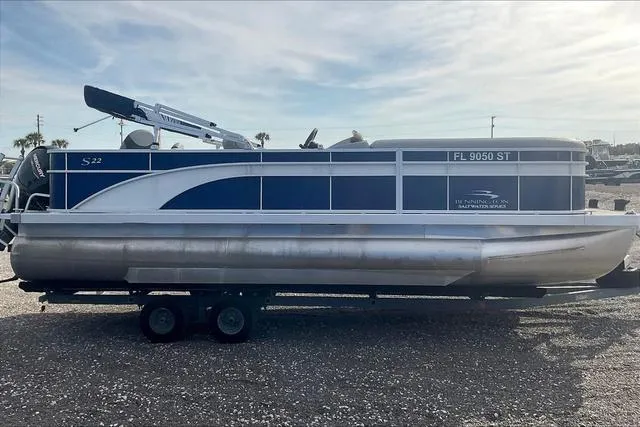 Slide: The Image of 2021 Bennington 22 SL pontoon boat on trailer, side view, blue and white design. - 8