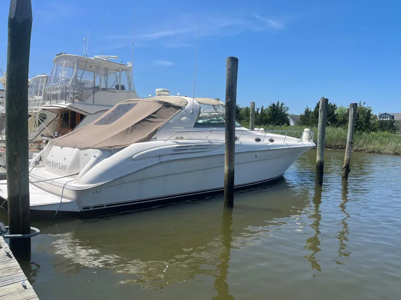 The Image of 1996 Sea Ray 450 Sundancer yacht docked in a marina under clear blue skies. - 0