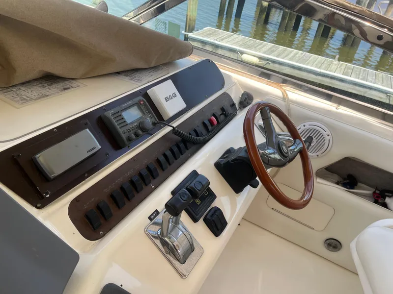 Slide: The Image of 1996 Sea Ray 450 Sundancer helm with steering wheel and navigation controls. - 10