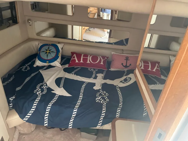 Slide: The Image of Cozy cabin interior of 1996 Sea Ray 450 Sundancer with nautical-themed bedding and pillows. - 18