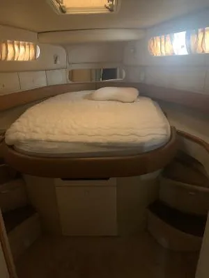 Slide: The Image of 1996 Sea Ray 450 Sundancer cabin with bed, soft lighting, and cozy interior. - 26