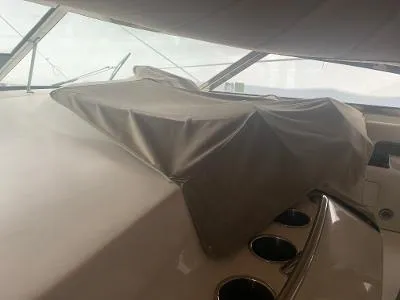 Slide: The Image of 1996 Sea Ray 450 Sundancer interior with covered dashboard and cup holders. - 28