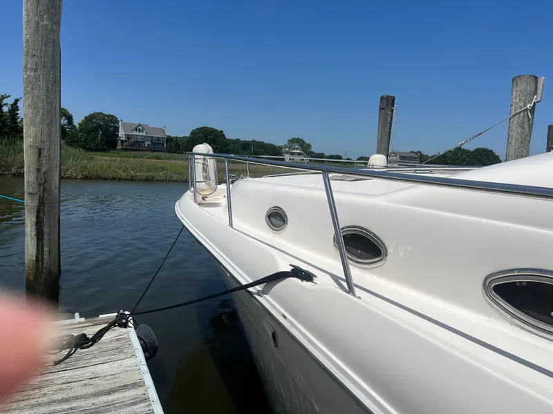 Slide: The Image of 1996 Sea Ray 450 Sundancer yacht docked by a wooden pier on a sunny day. - 5