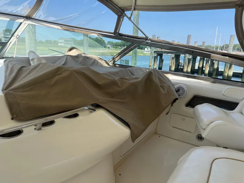 Slide: The Image of Interior of 1996 Sea Ray 450 Sundancer yacht with covered dashboard and white seating. - 9