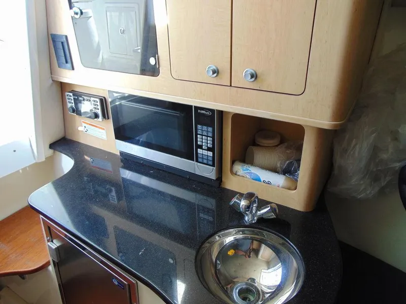 Slide: The Image of 2011 Hydra-Sports 3000VX Express boat kitchen with microwave, sink, and storage cabinets. - 24