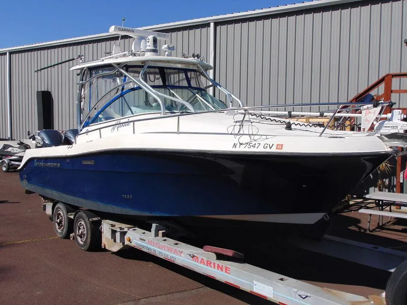 Slide: The Image of 2011 Hydra-Sports 3000VX Express boat on trailer, parked outside a warehouse. - 3
