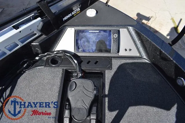 Slide: The Image of 2024 Triton 206 Allure boat dashboard with navigation system and foot pedal controls. - 13