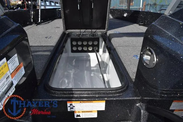 Slide: The Image of 2024 Triton 206 Allure boat storage compartment with warning labels, showcased by Thayer's Marine. - 19