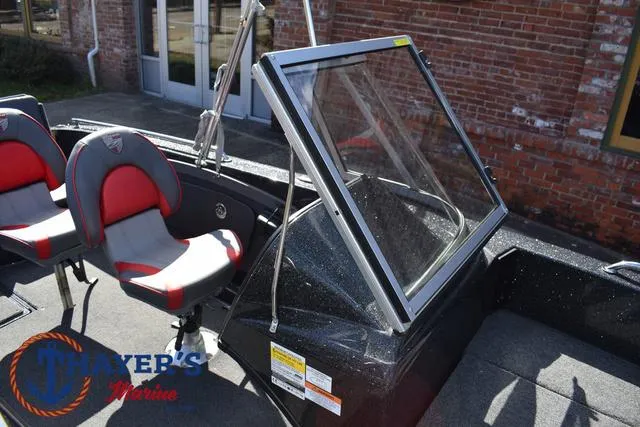 Slide: The Image of 2024 Triton 206 Allure boat interior with red and gray seating, windshield, and Thayer's Marine logo. - 21