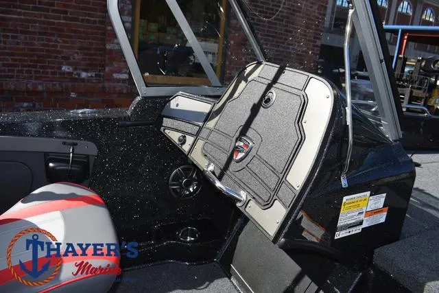 Slide: The Image of 2024 Triton 206 Allure boat interior with dashboard and seating, featuring Thayer's Marine logo. - 24