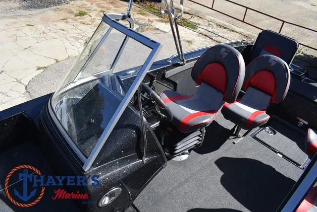 Slide: The Image of 2024 Triton 206 Allure boat interior with dual seats, steering console, and Thayer's Marine logo. - 27