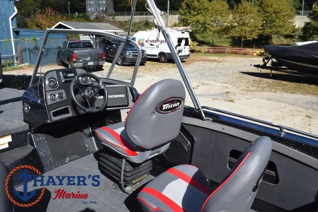 Slide: The Image of 2024 Triton 206 Allure boat interior with steering console and seating at Thayer's Marine. - 28