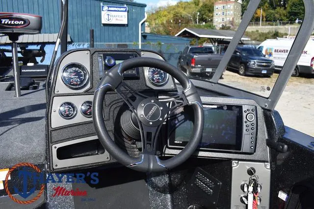 Slide: The Image of 2024 Triton 206 Allure boat dashboard with steering wheel and control panel. - 30