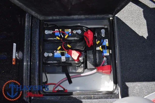Slide: The Image of 2024 Triton 206 Allure boat battery compartment with multiple batteries and wiring. - 35