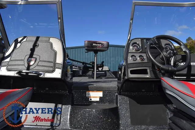 Slide: The Image of 2024 Triton 206 Allure boat interior with steering wheel and seating, Thayer's Marine logo visible. - 36