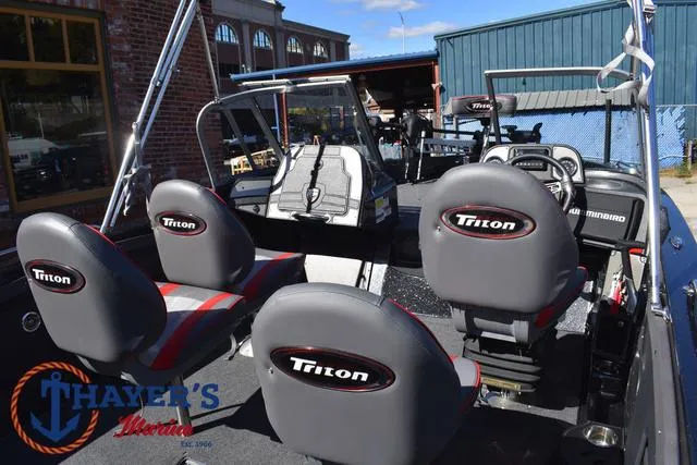 Slide: The Image of 2024 Triton 206 Allure boat interior with seating and controls, displayed at Thayer's Marine. - 38