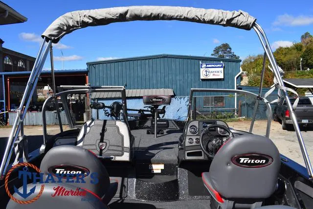 Slide: The Image of 2024 Triton 206 Allure boat interior with steering console and seating at Thayer's Marine. - 39