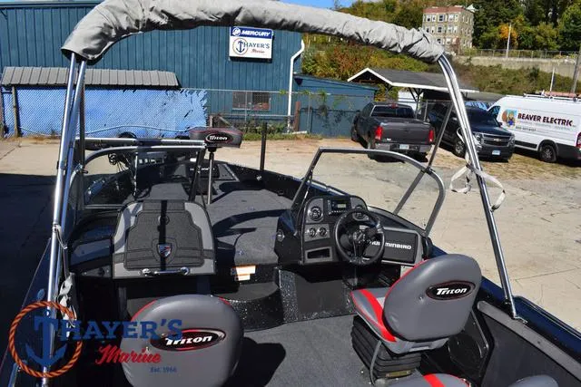 Slide: The Image of 2024 Triton 206 Allure boat interior with steering console and seating at Thayer's Marine. - 40